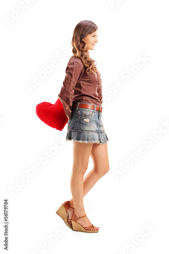 Photo: Young female holding a red heart behind her back Young female holding a red heart behind her back