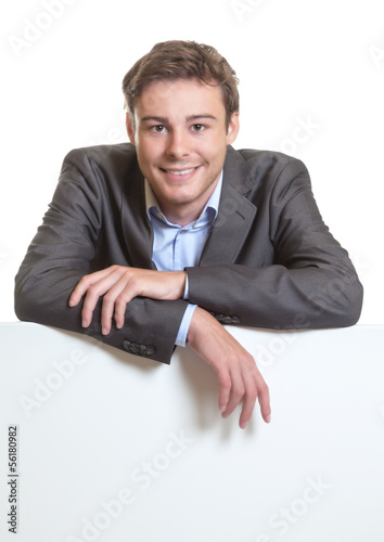 Photo: Young businessman behind a signboard Young businessman behind a signboard