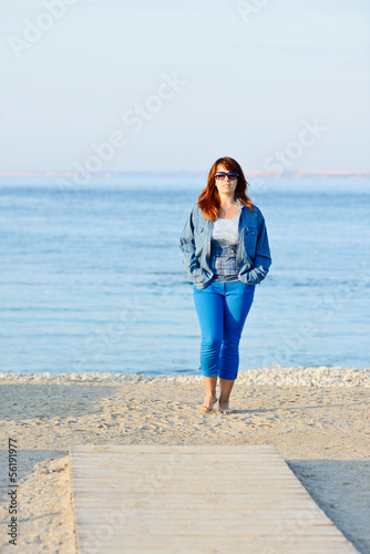 Photo: woman walking near the sea woman walking near the sea