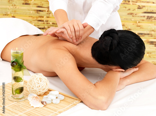 Photo: Woman on therapy massage of back in spa salon Woman on therapy massage of back in spa salon