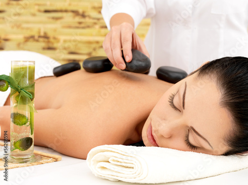 Photo: Woman having hot stone massage of back in spa salon Woman having hot stone massage of back in spa salon