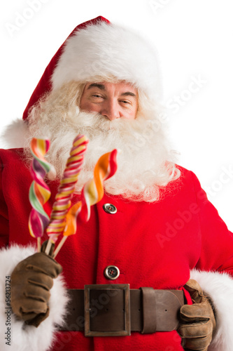 Photo: Portrait of happy Santa Claus holding candy looking at camera Portrait of happy Santa Claus holding candy looking at camera