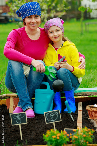 Photo: Gardening - girl helping mother in the garden Gardening - girl helping mother in the garden