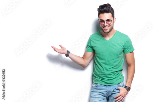 Photo: casual man presents something at his side casual man presents something at his side