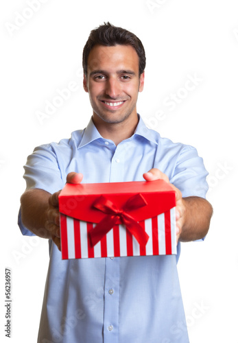 Photo: Laughing latin man hands over the christmas present Laughing latin man hands over the christmas present