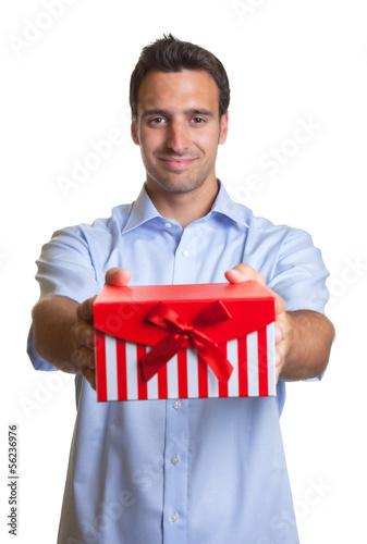 Photo: Smiling latin man hands over the christmas present Smiling latin man hands over the christmas present