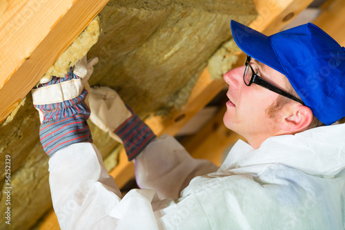 Photo: Handwerker schneidet Dämmmaterial Handwerker schneidet Dämmmaterial
