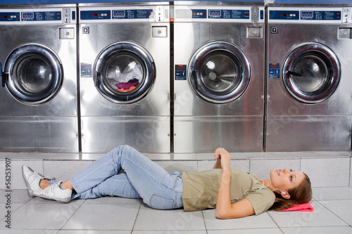 Photo: Woman Listening To Music While Lying At Laundry Woman Listening To Music While Lying At Laundry