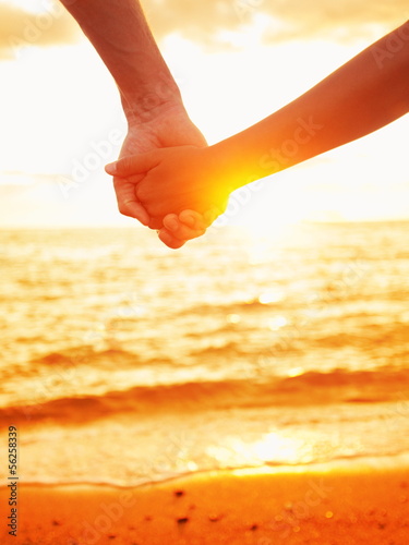 Photo: Love - couple holding hands in love, beach sunset Love - couple holding hands in love, beach sunset