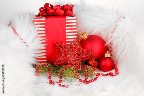 Photo: Christmas gift and red christmas balls in white fur Christmas gift and red christmas balls in white fur