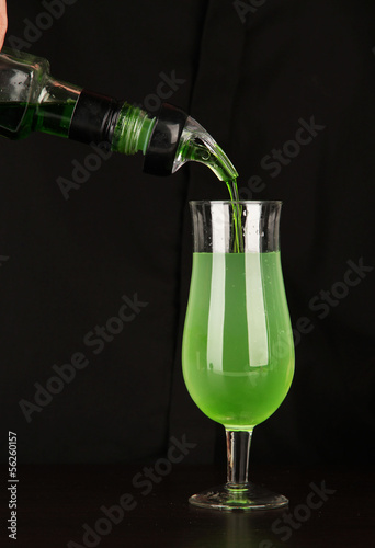 Photo: Bartender making cocktail on bright background, close-up Bartender making cocktail on bright background, close-up