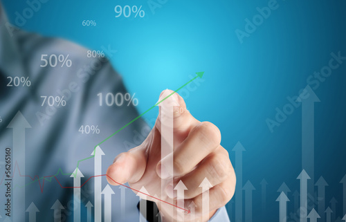 Photo: Business man pushing graph Business man pushing graph