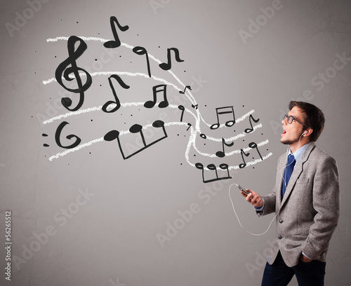 Photo: handsome boy singing and listening to music with musical notes handsome boy singing and listening to music with musical notes