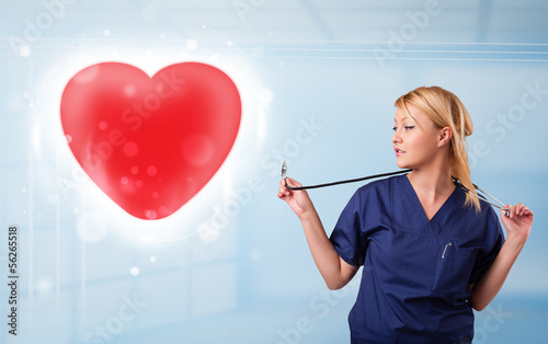 Photo: Young nurse healing a red heart Young nurse healing a red heart