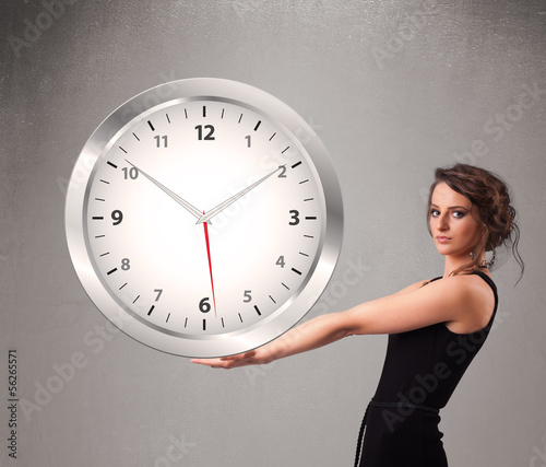 Photo: Attractive lady holding a huge clock Attractive lady holding a huge clock