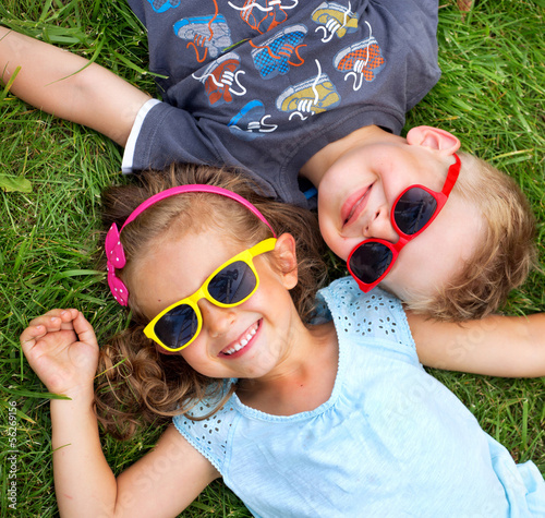 Photo: Picture presenting kids relaxinng on the grass Picture presenting kids relaxinng on the grass