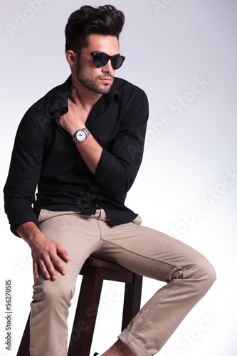 Photo: seated young man with hand tucked in shirt seated young man with hand tucked in shirt
