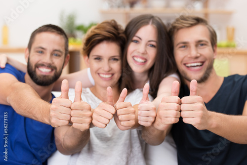 Photo: vier freunde lachen und zeigen daumen hoch vier freunde lachen und zeigen daumen hoch