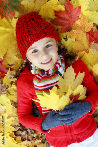 Photo: Autumn fun - lovely girl playing in autumn park Autumn fun - lovely girl playing in autumn park