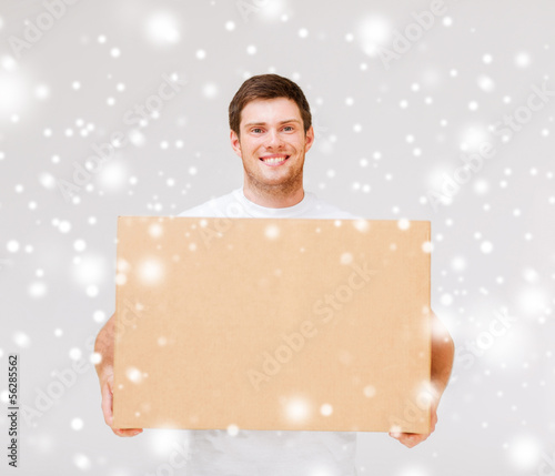 Photo: smiling man carrying carton box smiling man carrying carton box