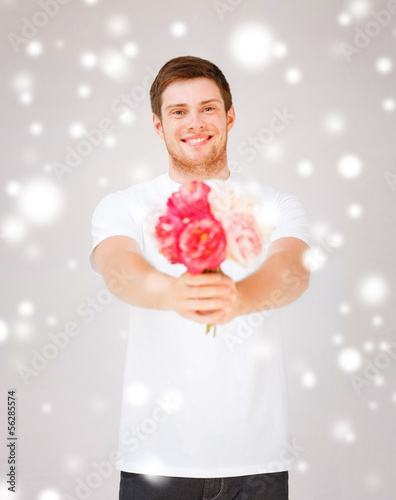 Photo: young man holding bouquet of flowers young man holding bouquet of flowers