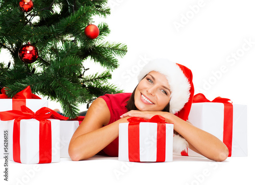 Photo: smiling woman in santa helper hat with gift boxes smiling woman in santa helper hat with gift boxes