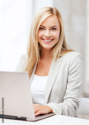 Photo: businesswoman with laptop in office businesswoman with laptop in office