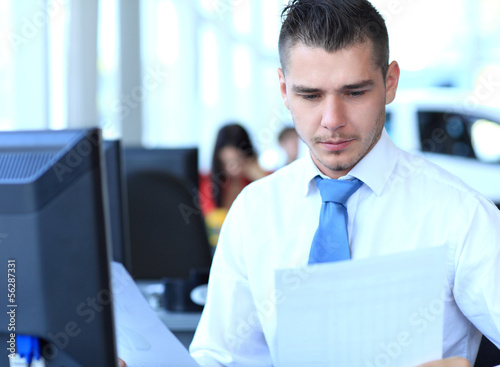 Photo: Happy businessman sitting and working in office Happy businessman sitting and working in office