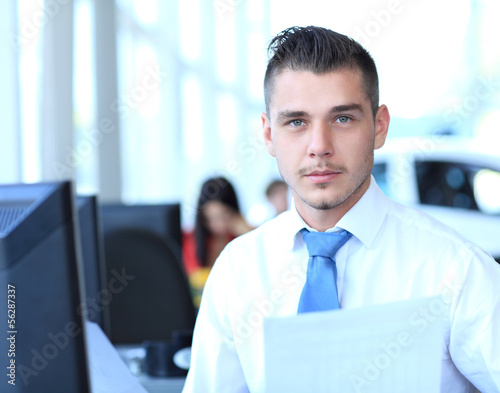 Photo: Happy businessman sitting and working in office Happy businessman sitting and working in office