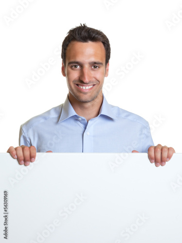 Photo: Smiling latin man with a signboard for advertising Smiling latin man with a signboard for advertising
