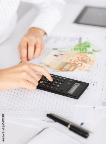 Photo: woman hand with calculator and euro money woman hand with calculator and euro money
