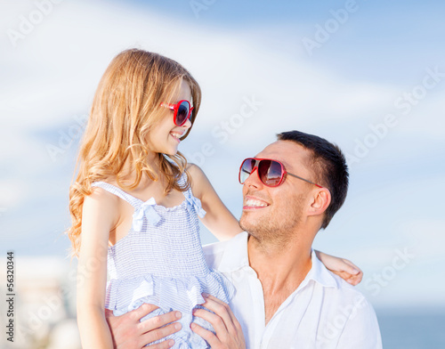 Photo: happy father and child in sunglasses over blue sky happy father and child in sunglasses over blue sky