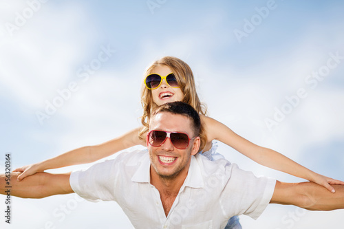 Photo: happy father and child in sunglasses over blue sky happy father and child in sunglasses over blue sky