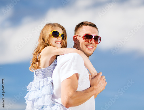 Photo: happy father and child in sunglasses over blue sky happy father and child in sunglasses over blue sky