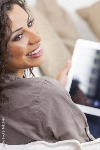 Photo: Hispanic Woman Laughing Using Tablet Computer Hispanic Woman Laughing Using Tablet Computer