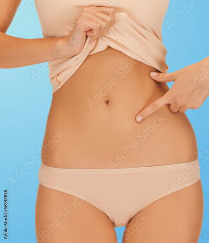 Photo: woman pointing at her abs woman pointing at her abs