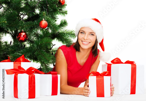 Photo: smiling woman in santa helper hat with gift boxes smiling woman in santa helper hat with gift boxes