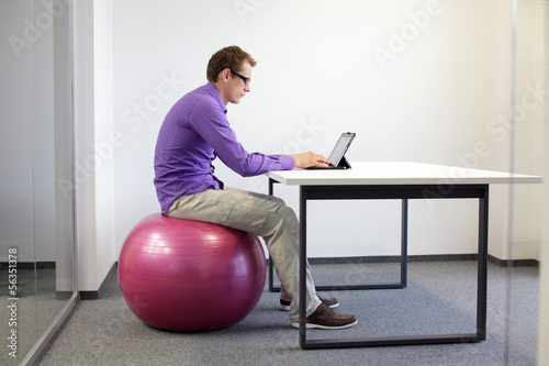 Photo: bad sitting posture at desk on stability ball with tablet bad sitting posture at desk on stability ball with tablet