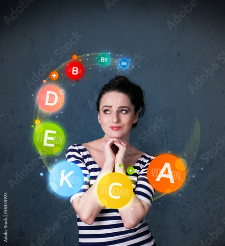 Photo: Young woman thinking with vitamins circulation around her head Young woman thinking with vitamins circulation around her head