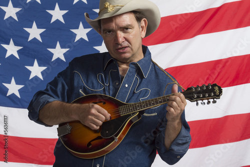 Photo: Man playing his mandolin in front of American flag, horizontal Man playing his mandolin in front of American flag, horizontal