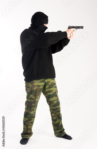 Photo: masked man aims with gun masked man aims with gun