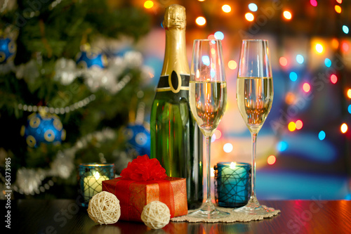 Photo: Glasses of champagne and gifts on bright background Glasses of champagne and gifts on bright background