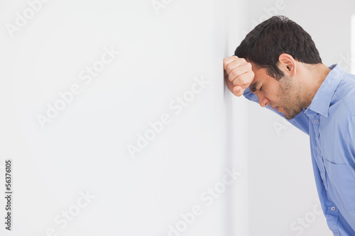 Photo: Angry man leaning his head against a wall Angry man leaning his head against a wall