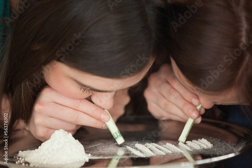 Photo: Two young girls snorting an illegal white powder Two young girls snorting an illegal white powder