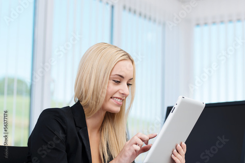 Photo: junge frau im büro arbeitet mit tablet junge frau im büro arbeitet mit tablet