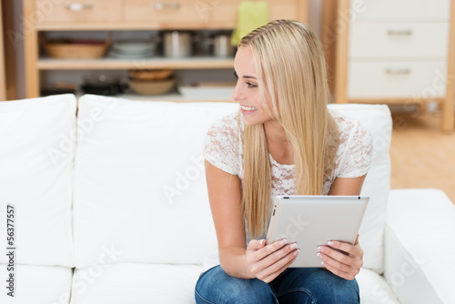 Photo: lächelnde studentin mit tablet in ihrer wohnung lächelnde studentin mit tablet in ihrer wohnung