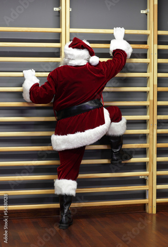 Photo: santa claus exercising wh wall bars,Christmas Time preparation santa claus exercising wh wall bars,Christmas Time preparation