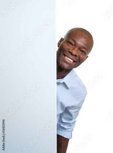 Photo: Laughing african businessman behind a signboard Laughing african businessman behind a signboard