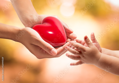 Photo: life in your hands - heart whit orange background life in your hands - heart whit orange background