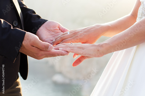 Photo: Wedding couple holding hands on sunset background Wedding couple holding hands on sunset background